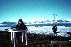 JW0PK 2001 – La stazione satellite all'aperto: uno alla radio, l'altro punta le antenne a mano.